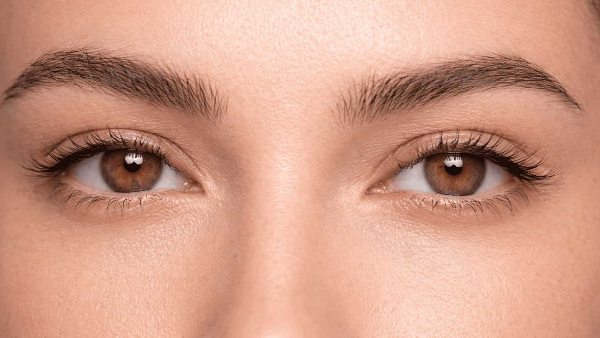 close-up of upturned eyes with lifted outer corners and natural lashes in soft neutral lighting