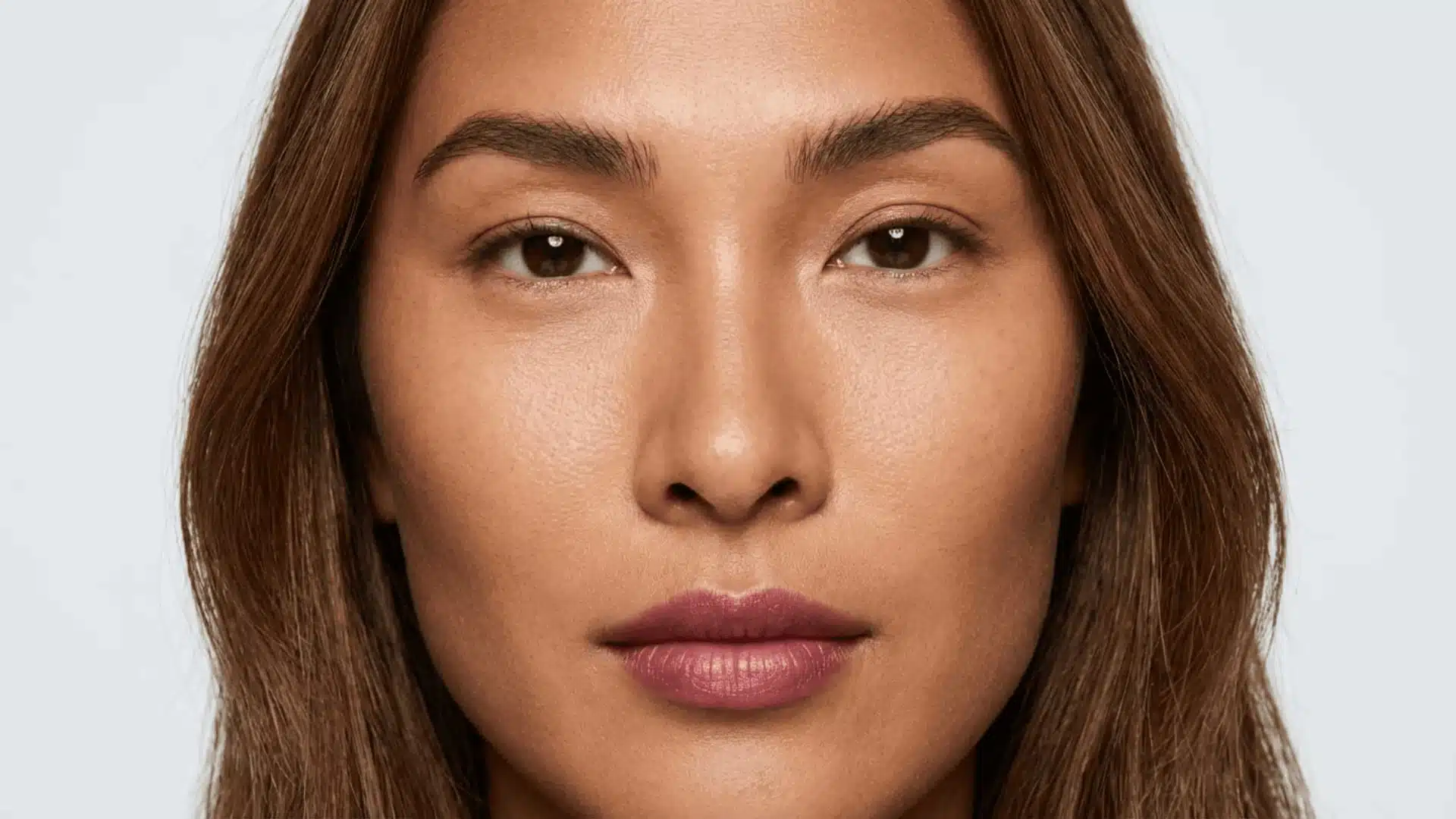 close-up portrait of a woman with monolid eyes, neutral expression, and soft natural lighting