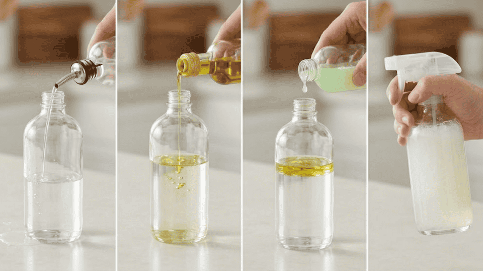 _hands pouring distilled water, oil, and essential oil into glass spray bottle labeled wood cleaner on kitchen counter