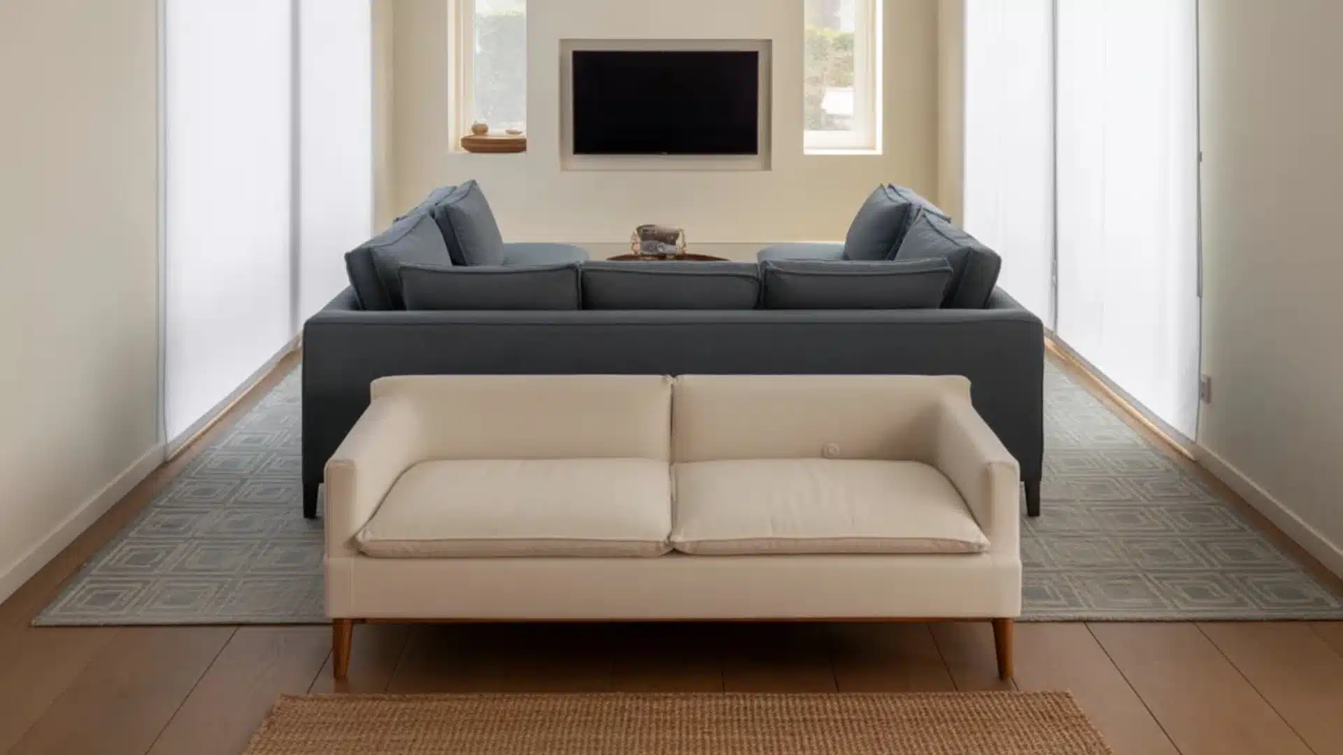 interior design photograph showcasing a cleverly arranged small living room with back-to-back seating zones creating two distinct areas