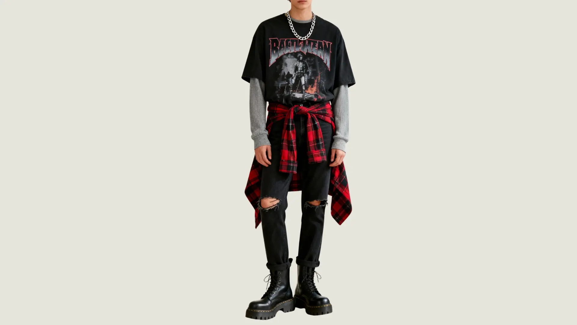 man in e-boy style wearing a graphic tee over a grey long-sleeve with ripped jeans and a flannel tied at the waist