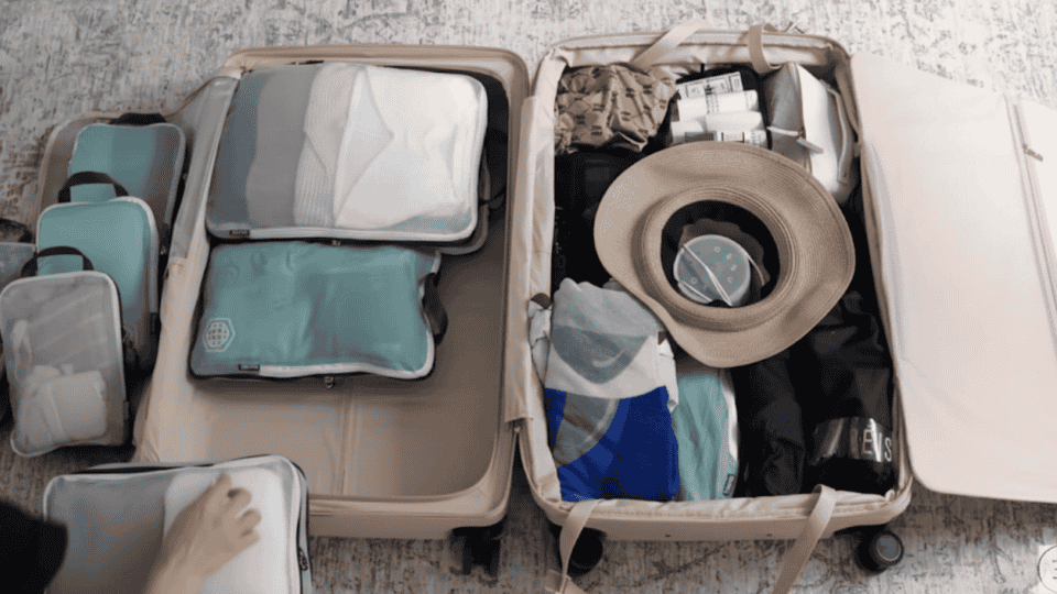 open suitcase with packing cubes separating clothing and accessories for efficient suitcase packing
