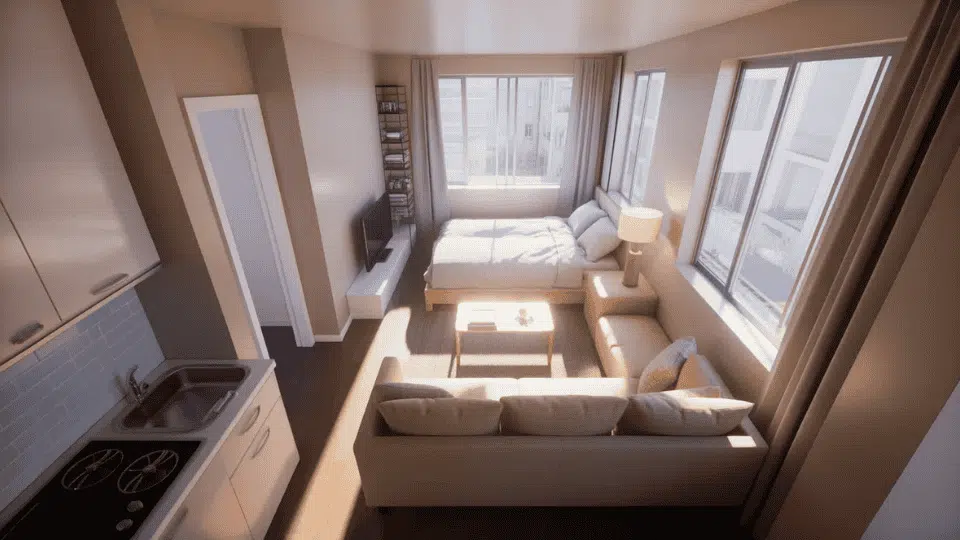 small studio with sofa placed back to bed creating a clear divider between sleeping and living areas.