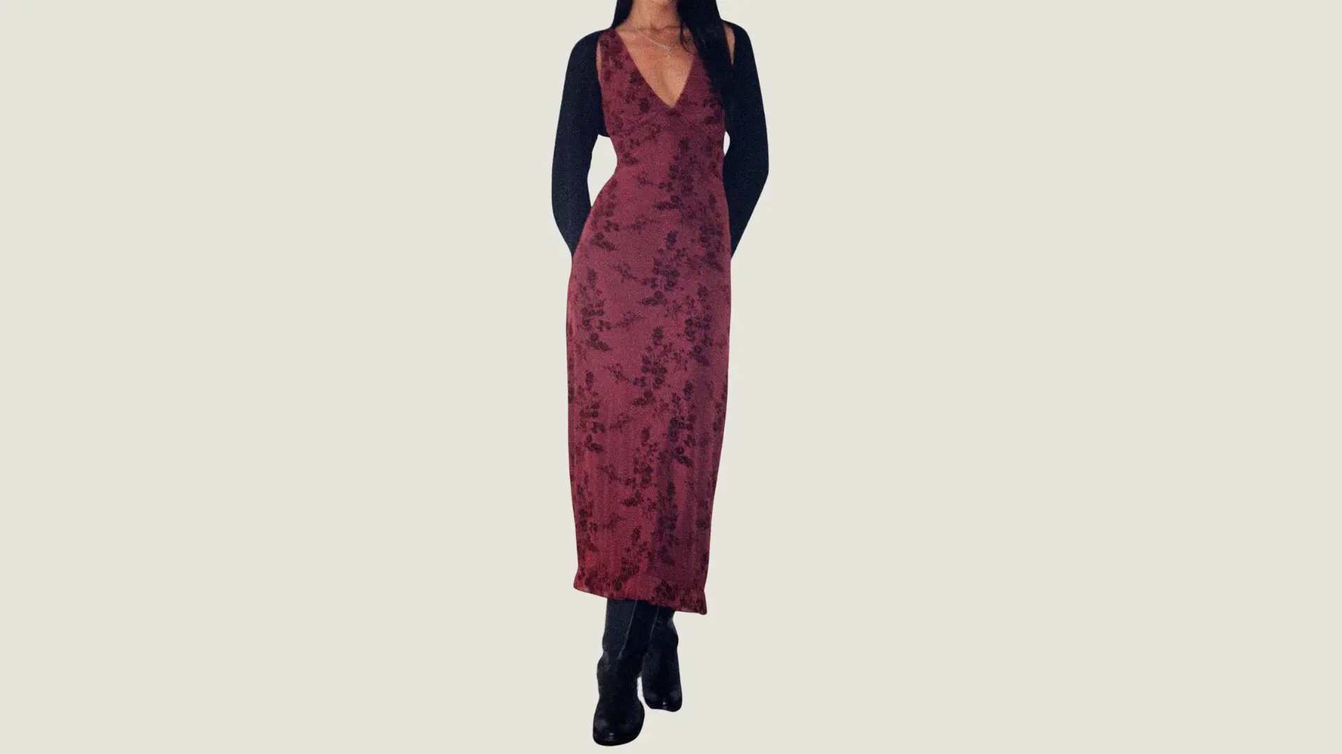 woman in a dark feminine style wearing a maroon floral slip dress with a black bolero and tall black leather boots
