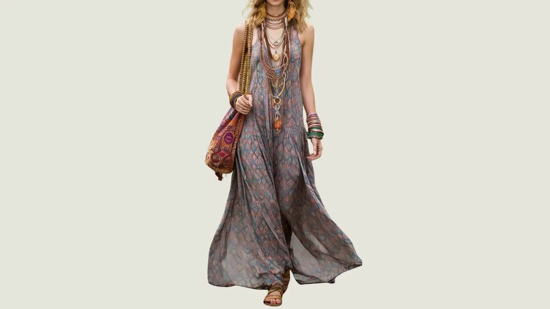 woman in bohemian style wearing a patterned maxi dress with layered necklaces and a large embroidered shoulder bag