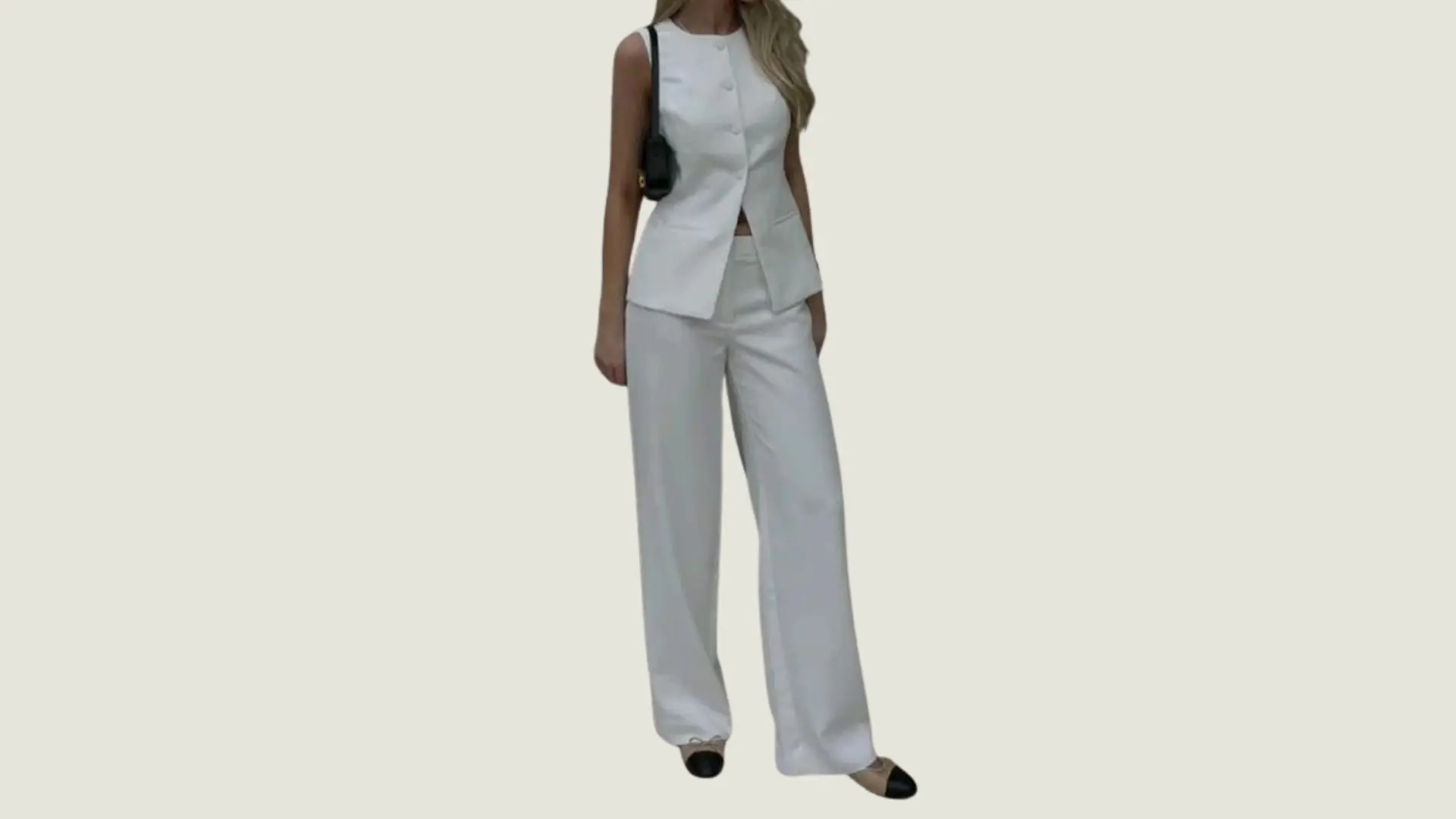 woman in clean girl style wearing a white sleeveless button-up vest with matching wide-leg trousers and black-toe flats