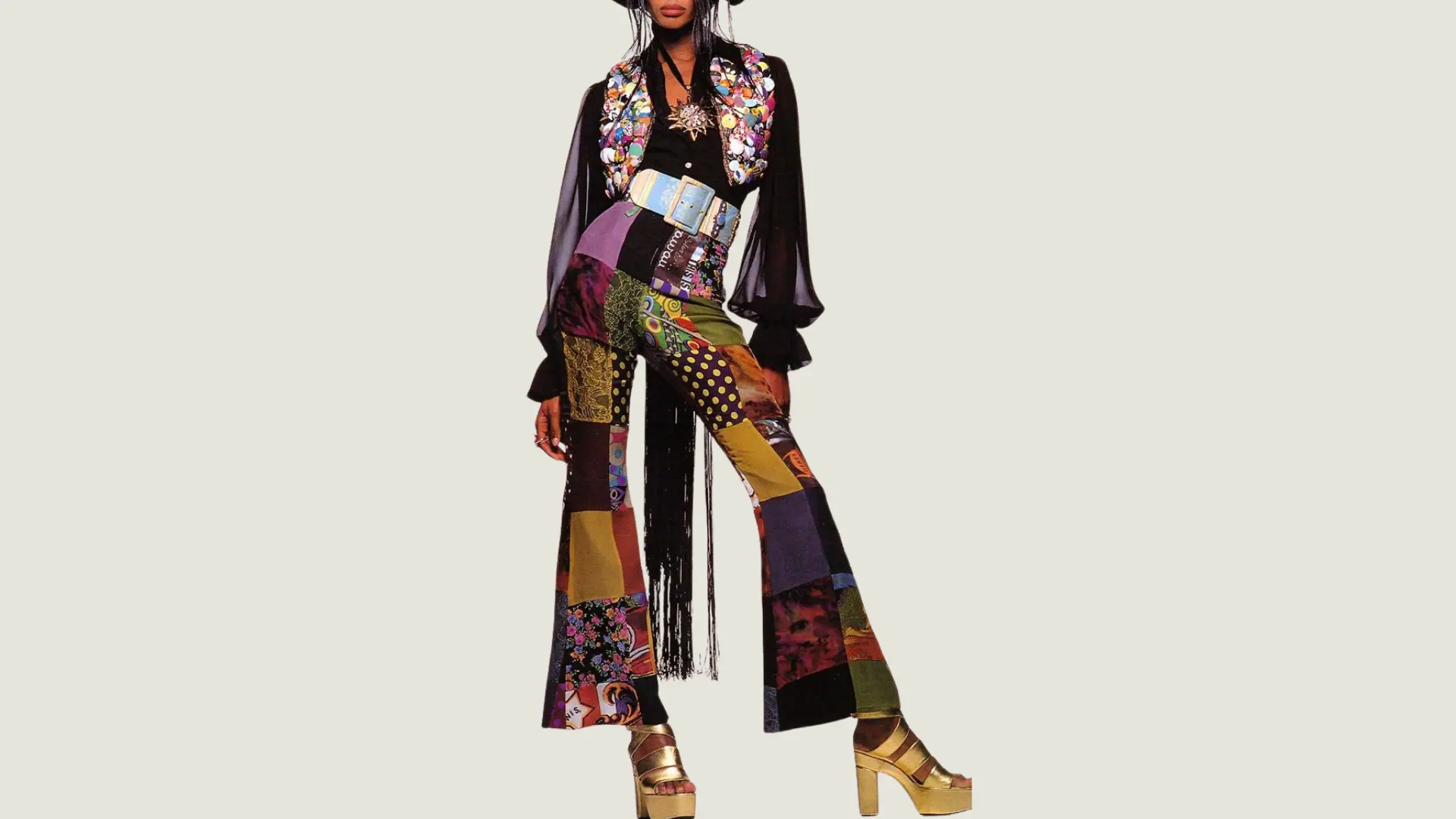 woman in maximalist style wearing colorful patchwork flared trousers with a sequin vest and gold platform heels