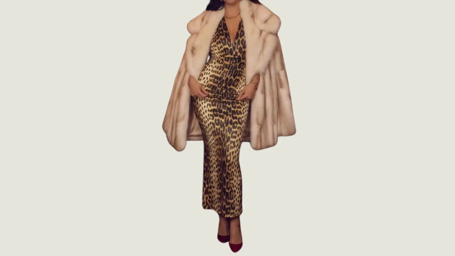 woman in mob wife style wearing a leopard print maxi dress with a white faux fur coat and burgundy pointed-toe heels