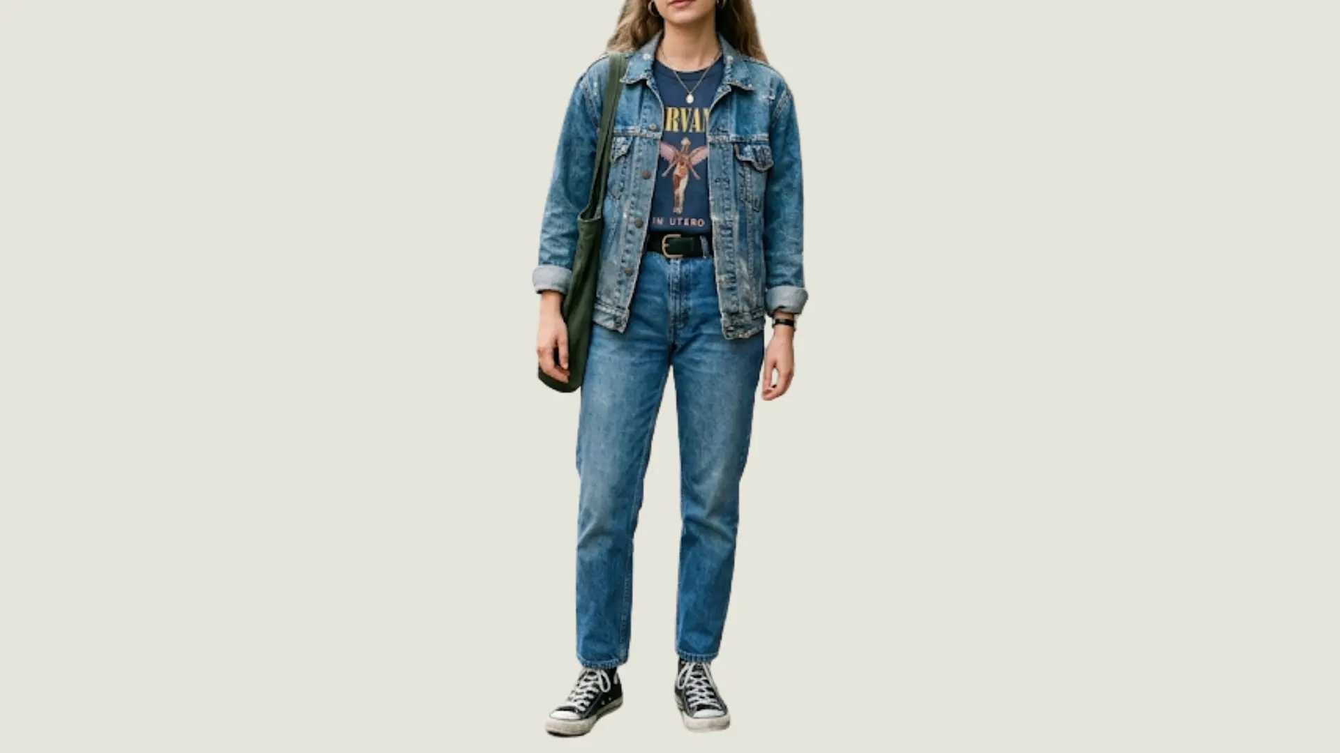 woman in vintage style wearing a denim jacket over a graphic band tee and blue jeans with high-top canvas sneakers