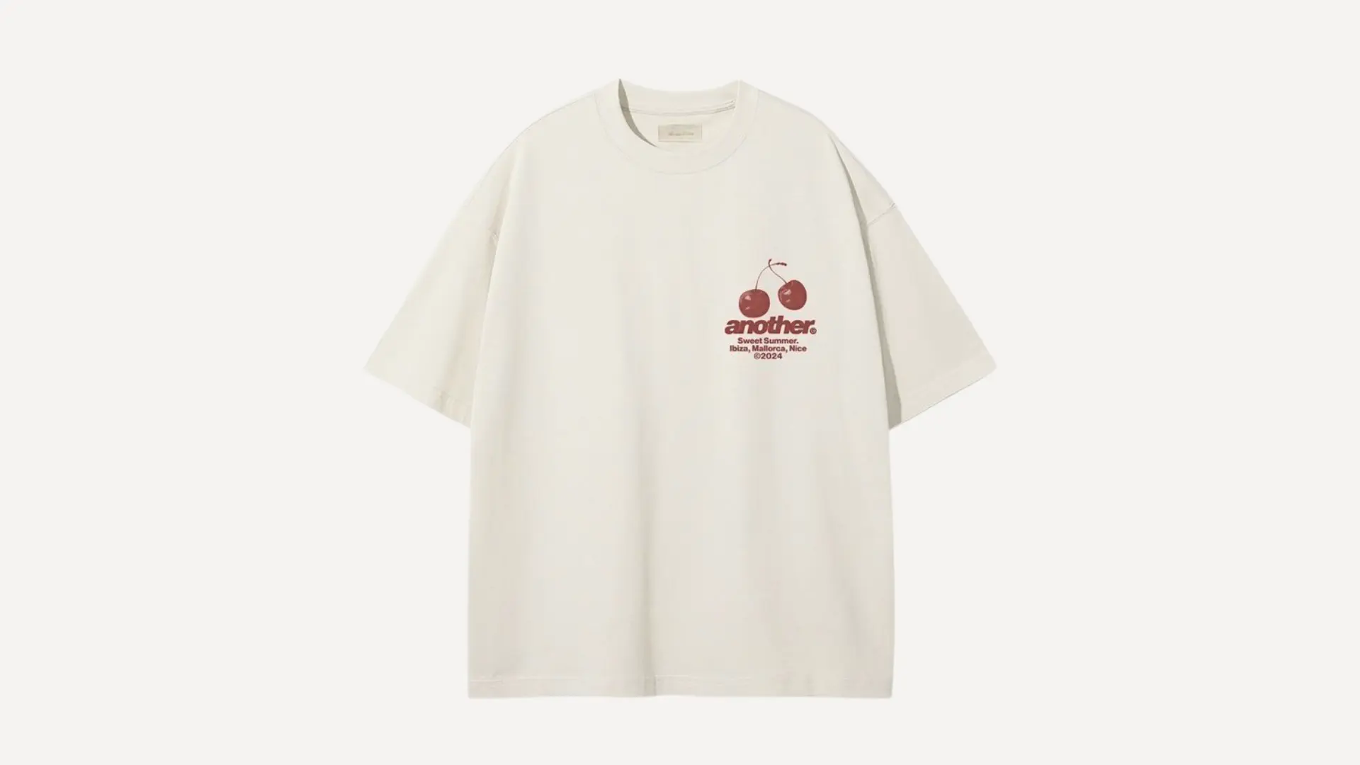 off-white oversized t-shirt with a small cherry graphic and the word another printed on the left chest area