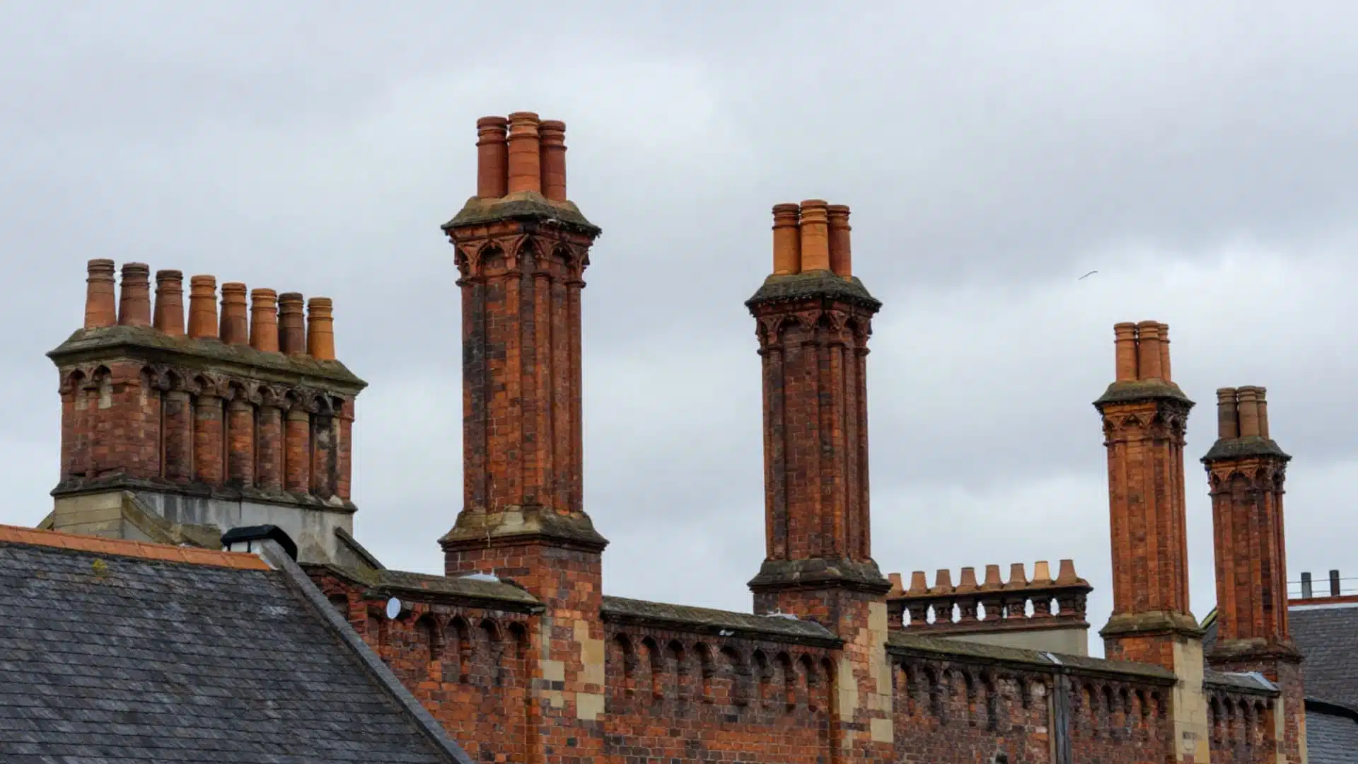 tudor house style tall decorative chimneys made of brick with patterned stacks ornate tops and clustered chimney designs on roof
