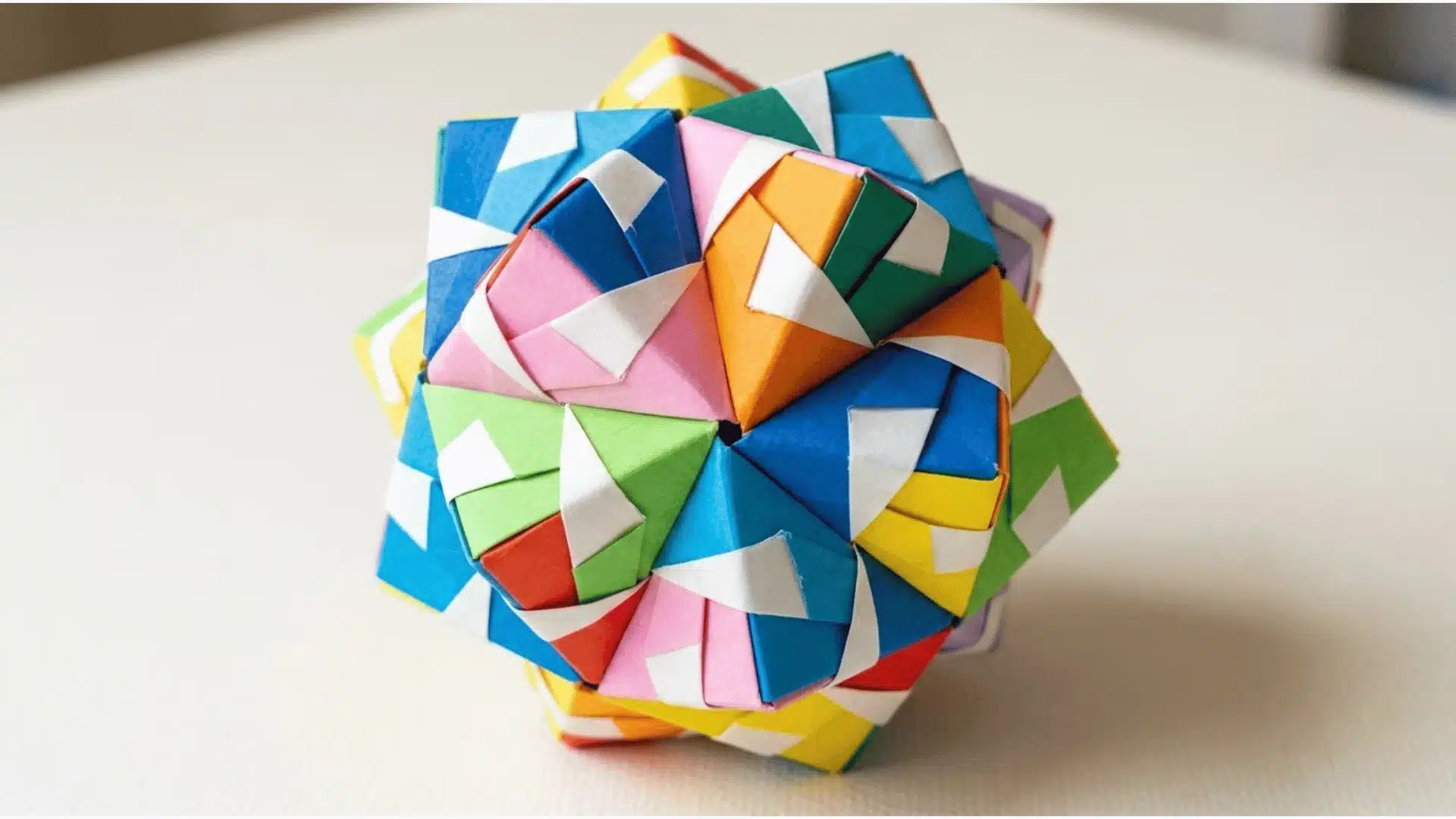 a colorful modular origami kusudama ball made from multiple folded paper units