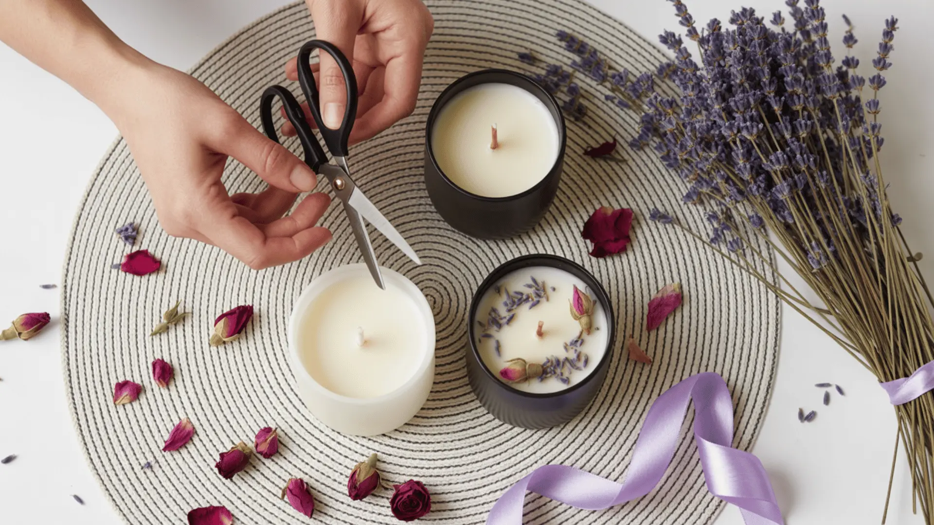 top-down view of candle-making supplies and ingredients on a black and white striped circular placemat