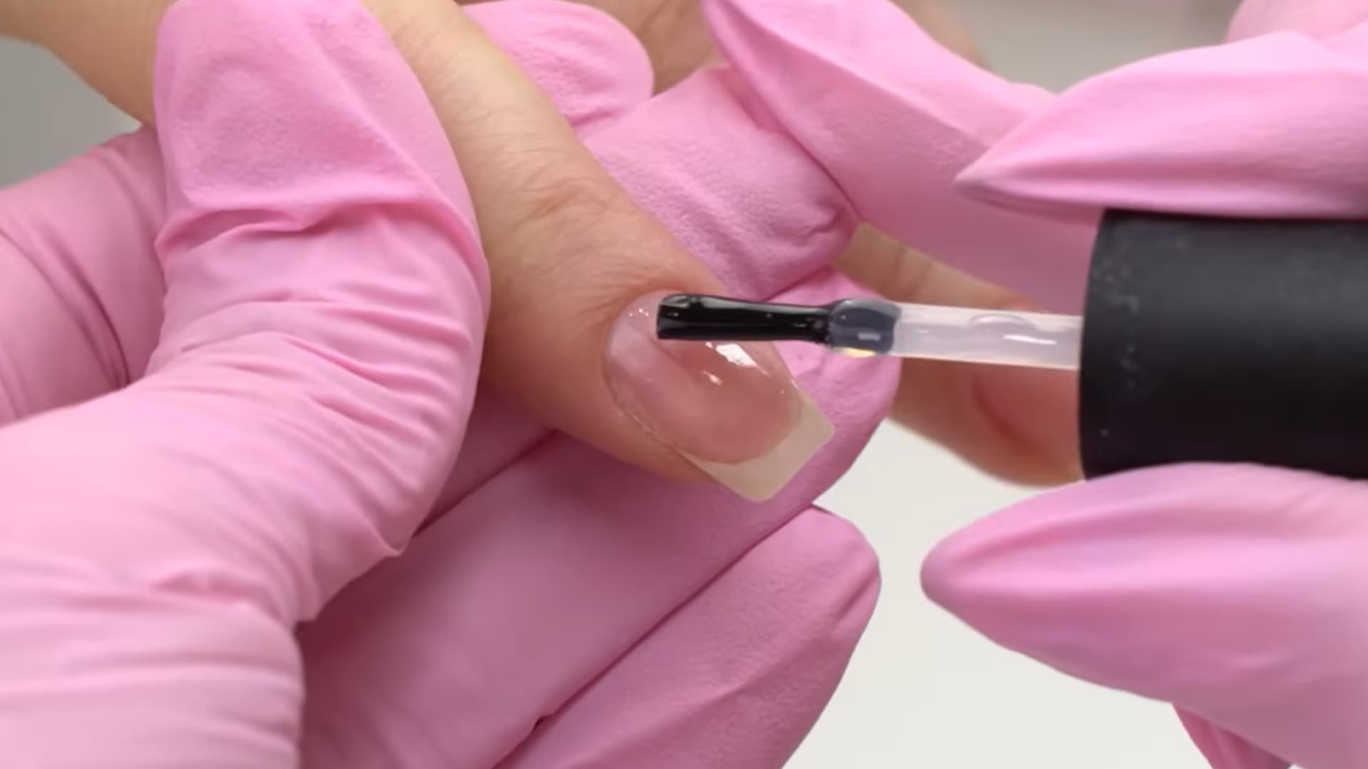 applying base coat to nails for manicure smooth polish layer on clean prepped nails soft beauty routine