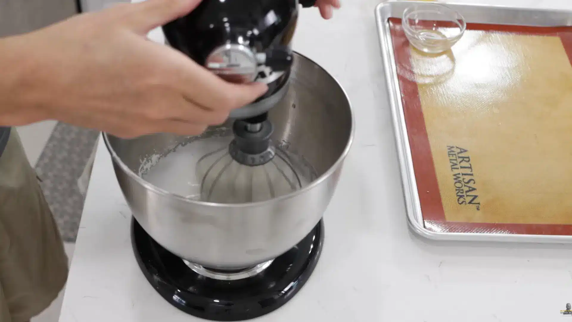 beating egg whites on high speed until stiff peaks form with glossy shaving cream texture