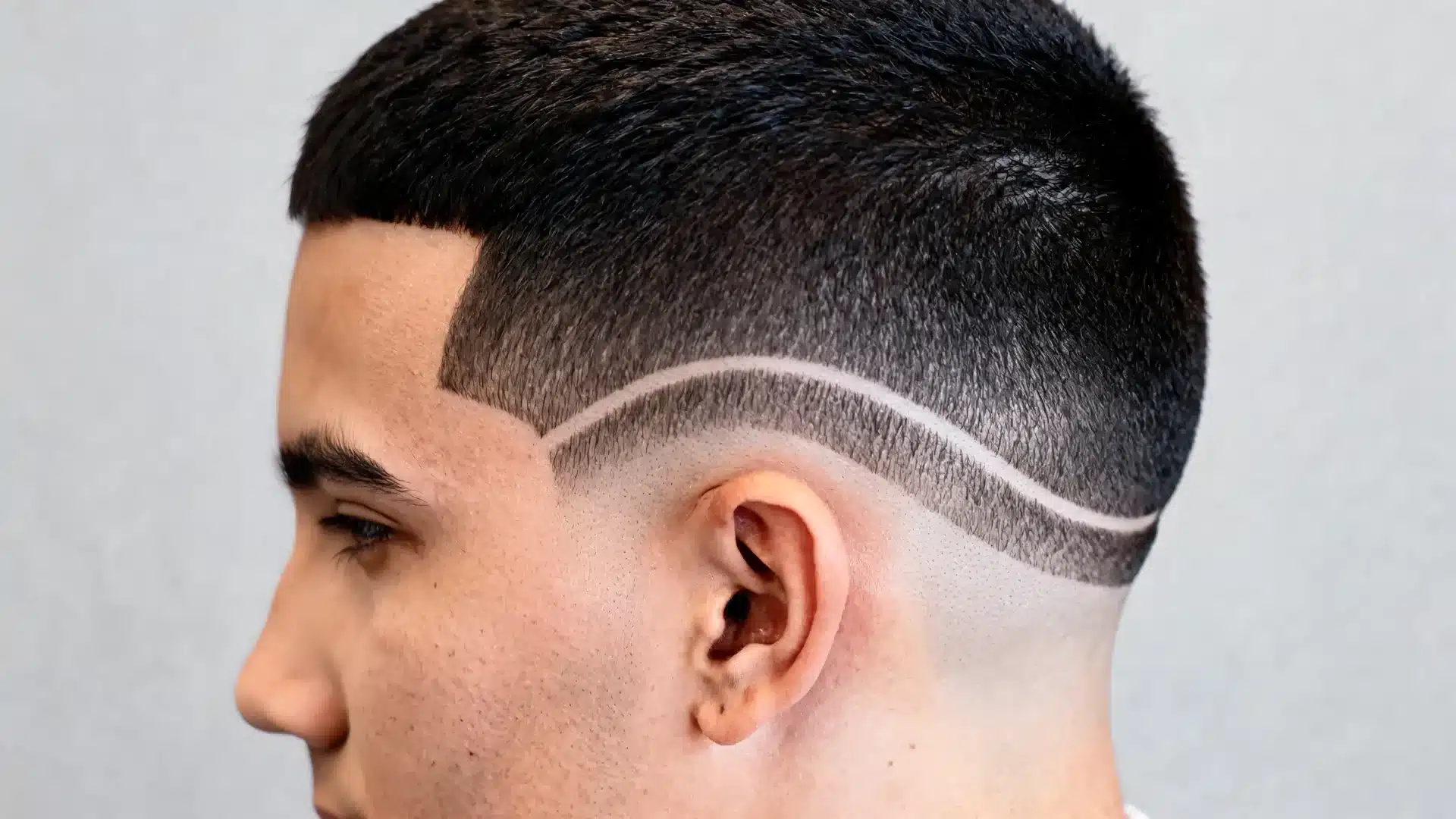 boys haircut with design featuring a curved side line fade around the temple area