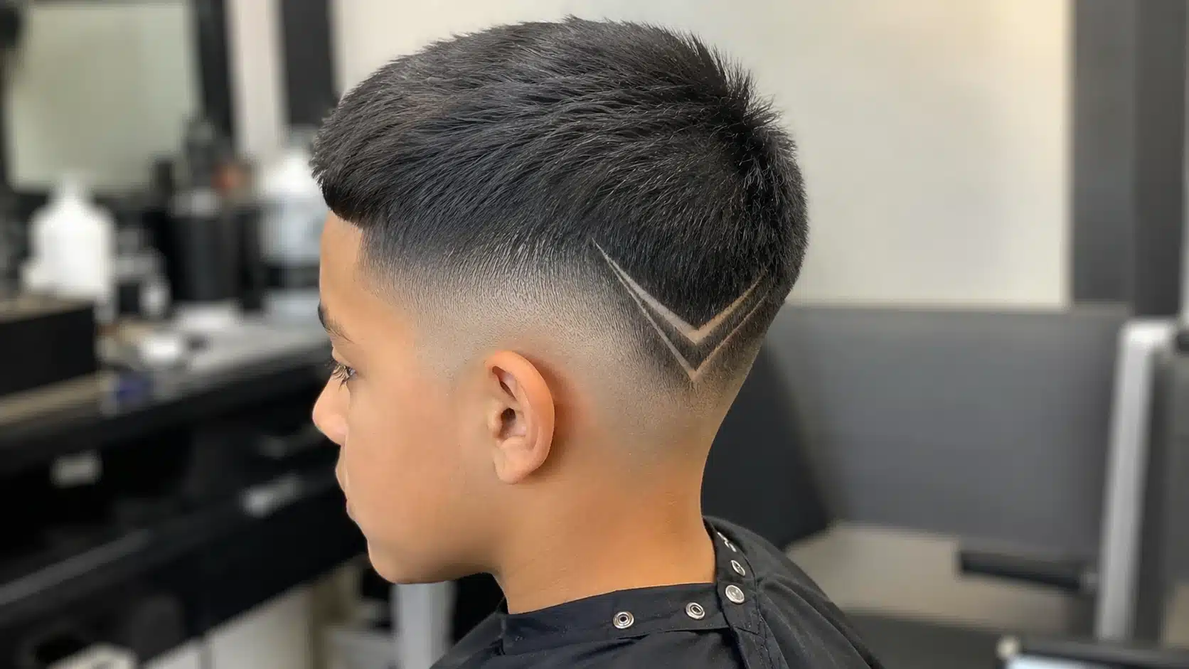 boys haircut with design showing a clean arrow line shaved into a short faded side