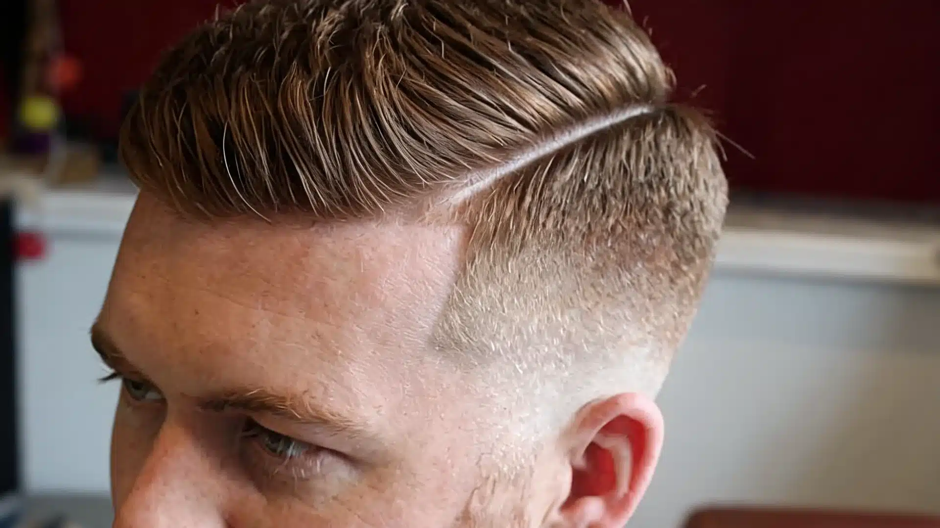 boys haircut with design showing a clean hard part with a neat side fade