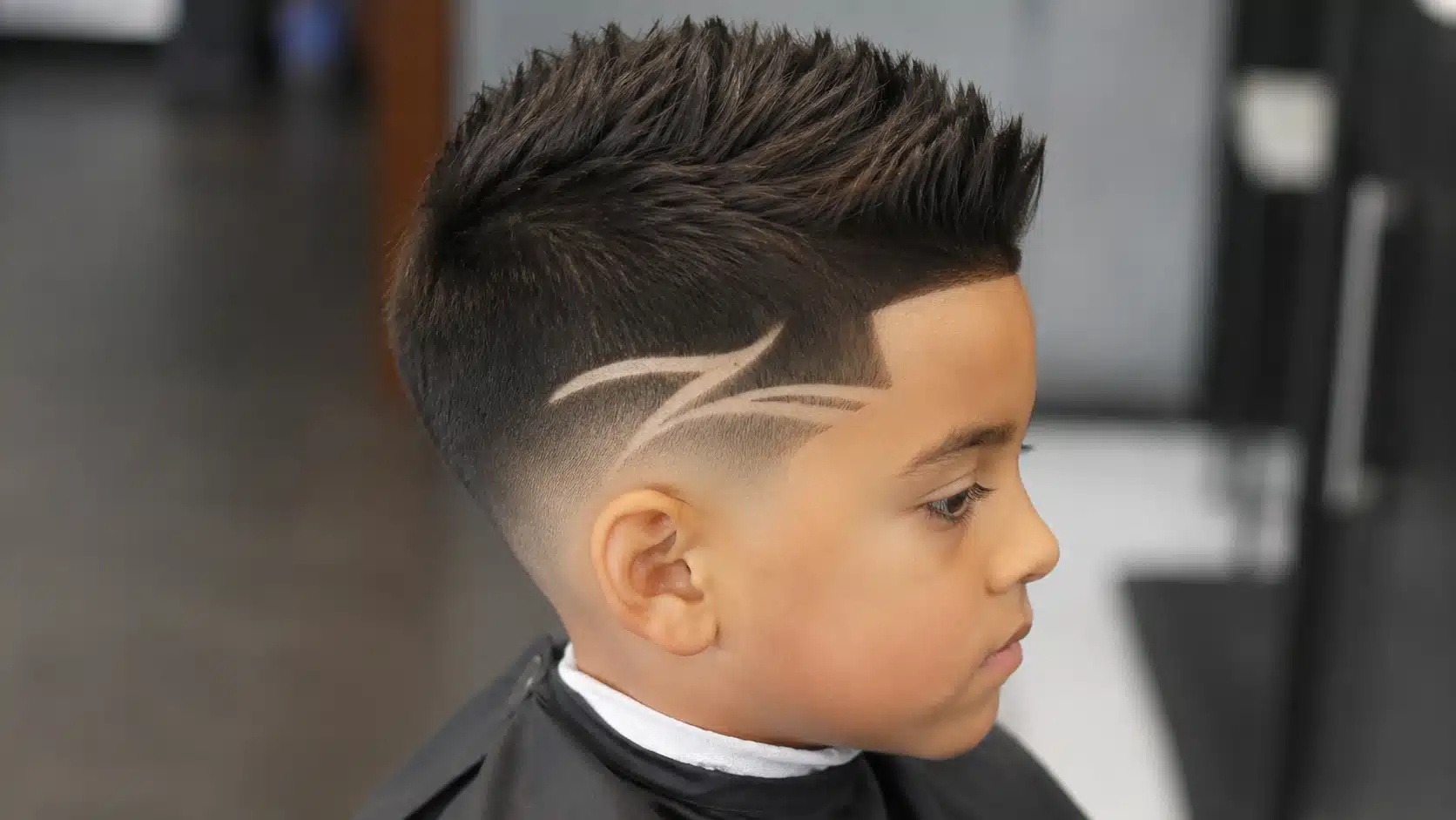 boys haircut with design showing a faux hawk with faded sides and a clean shaved line
