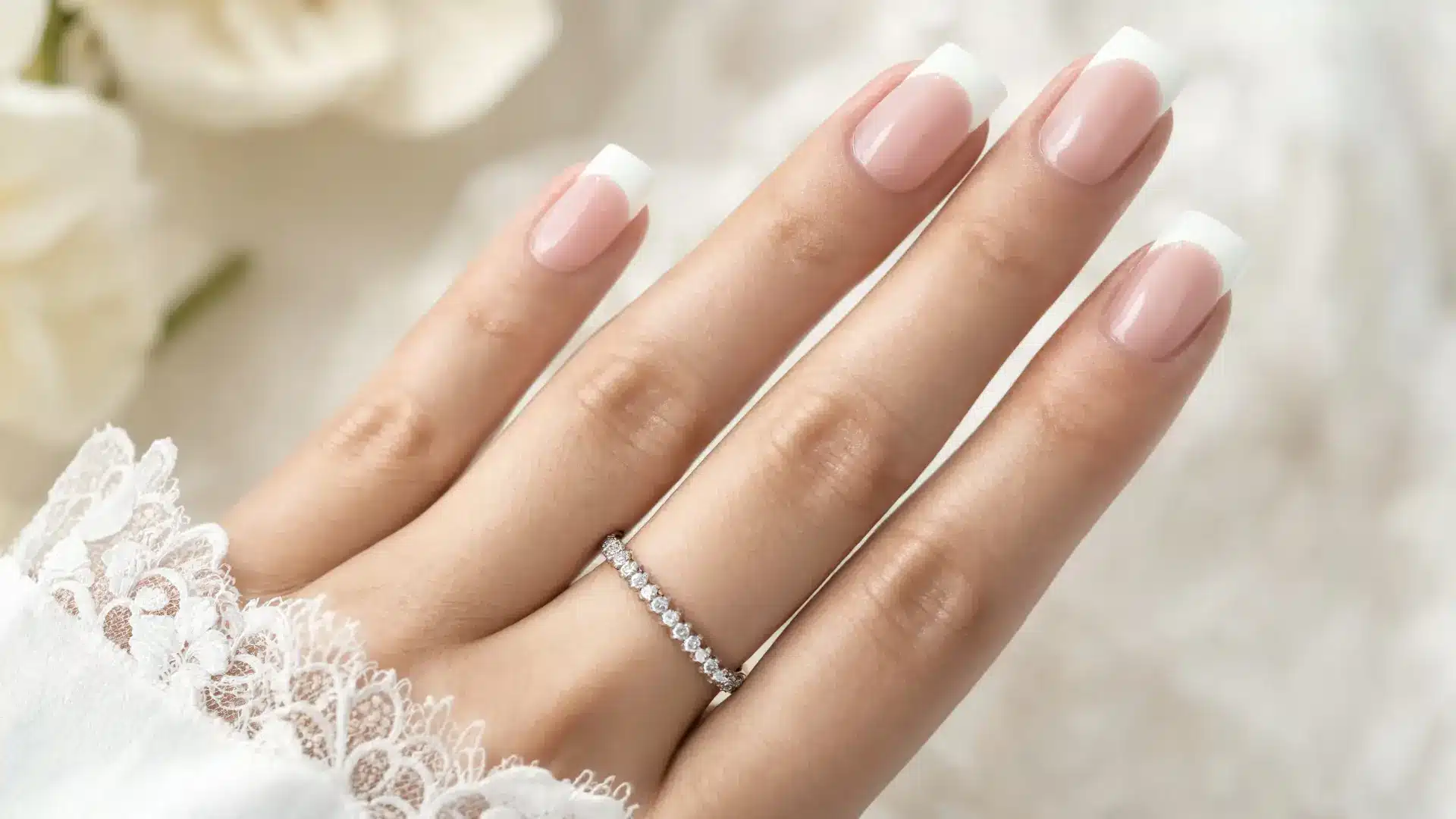 close up french tip acrylic extensions square and almond nails crisp white tips natural pink base soft studio lighting