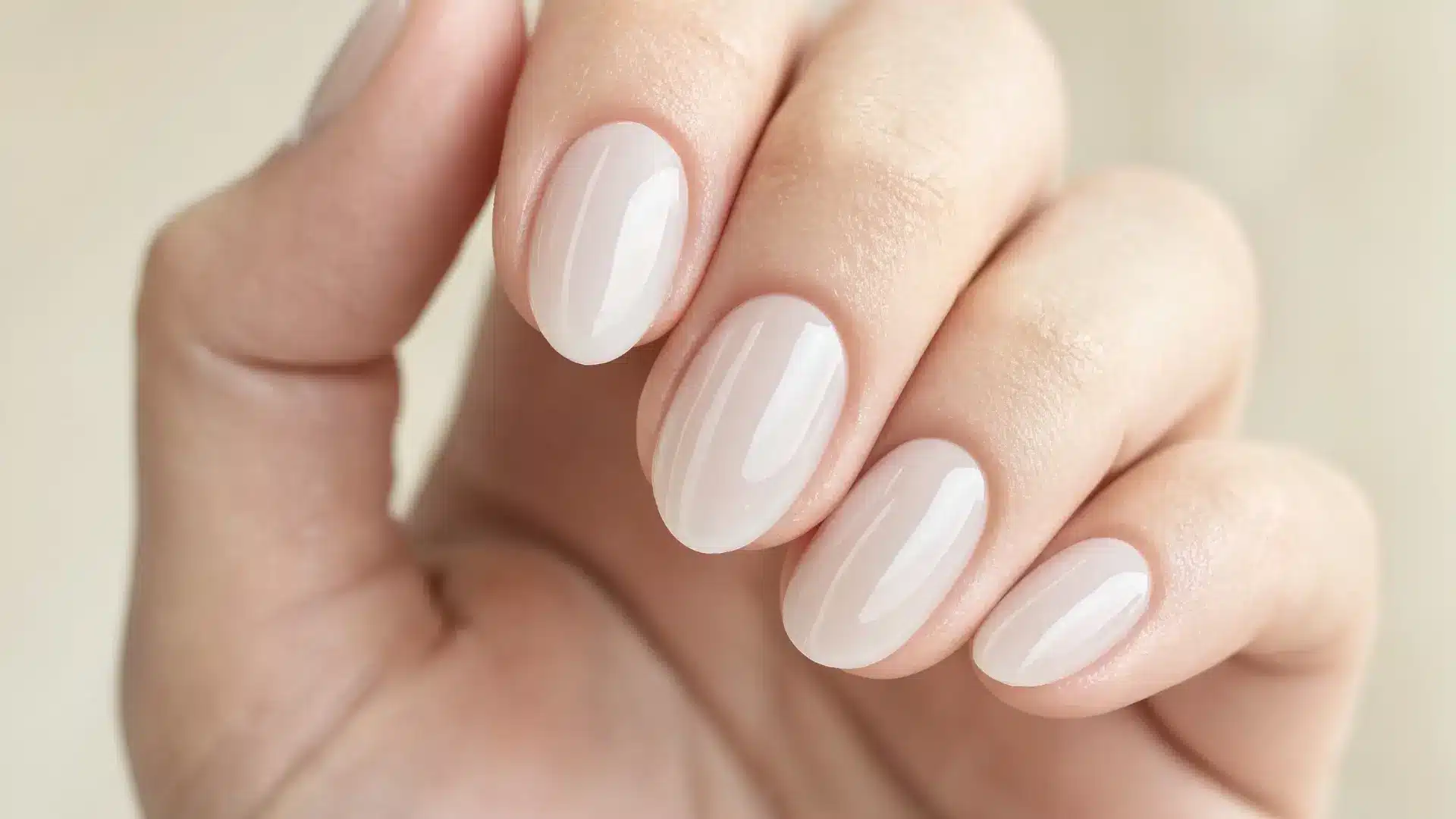 close up milky white soft gel nails almond shape semi transparent cloudy finish minimal clean beauty salon style soft light