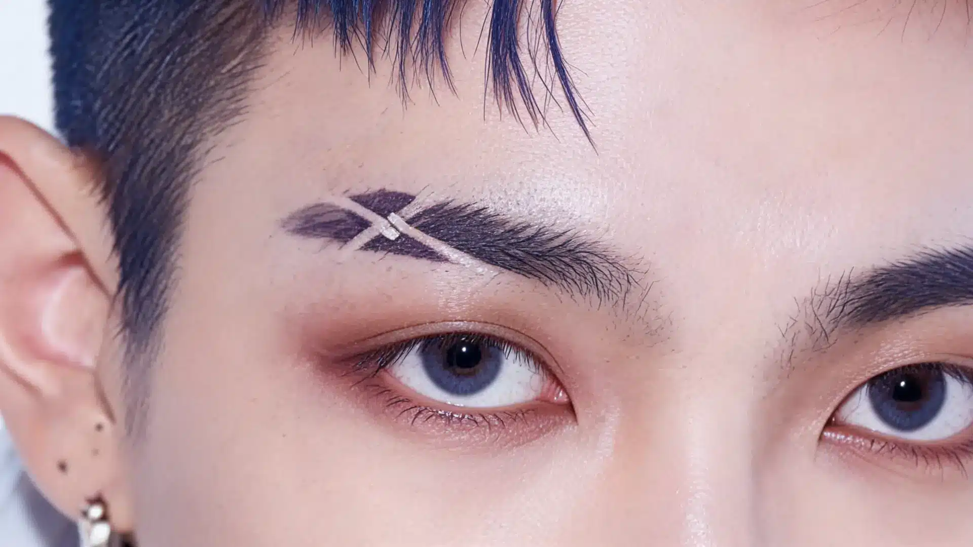 cross eyebrow slit with two angled cuts creating a sharp graphic brow detail on a thick natural eyebrow