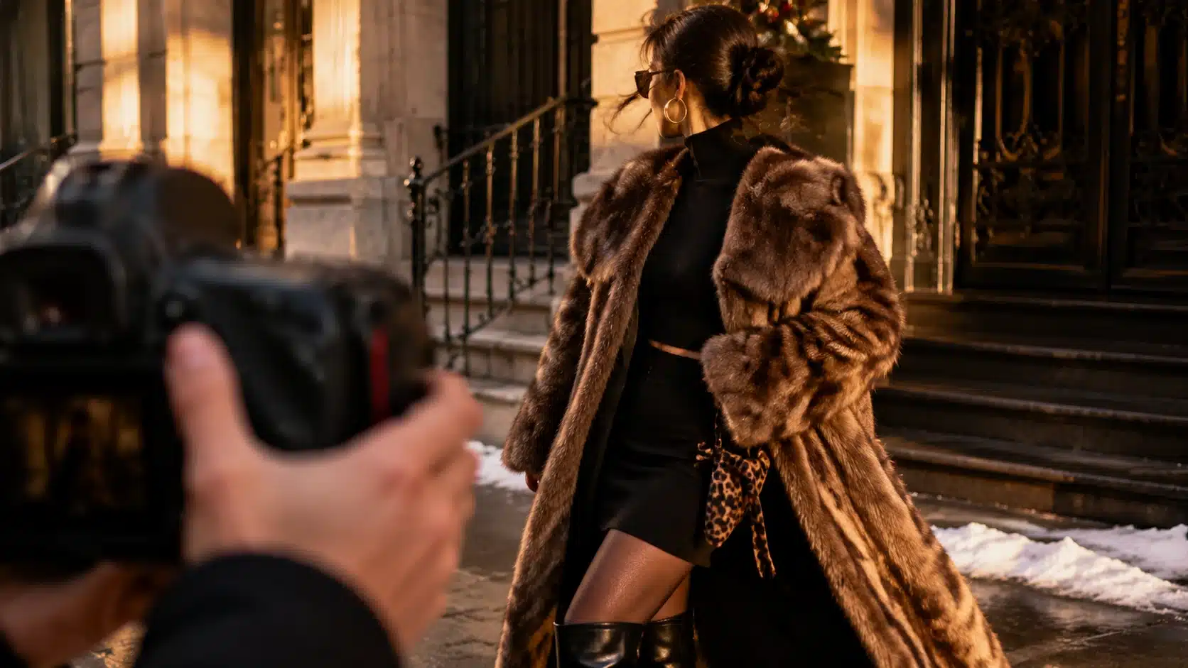 mob wife aesthetic outfit being photographed with faux fur, black boots, gold jewelry, and leopard detail