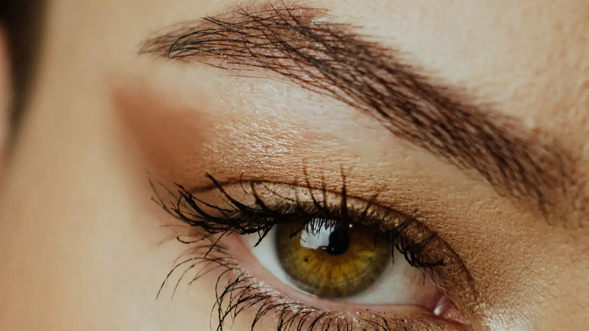 person with a tail eyebrow slit on a clean tapered brow in soft natural lighting