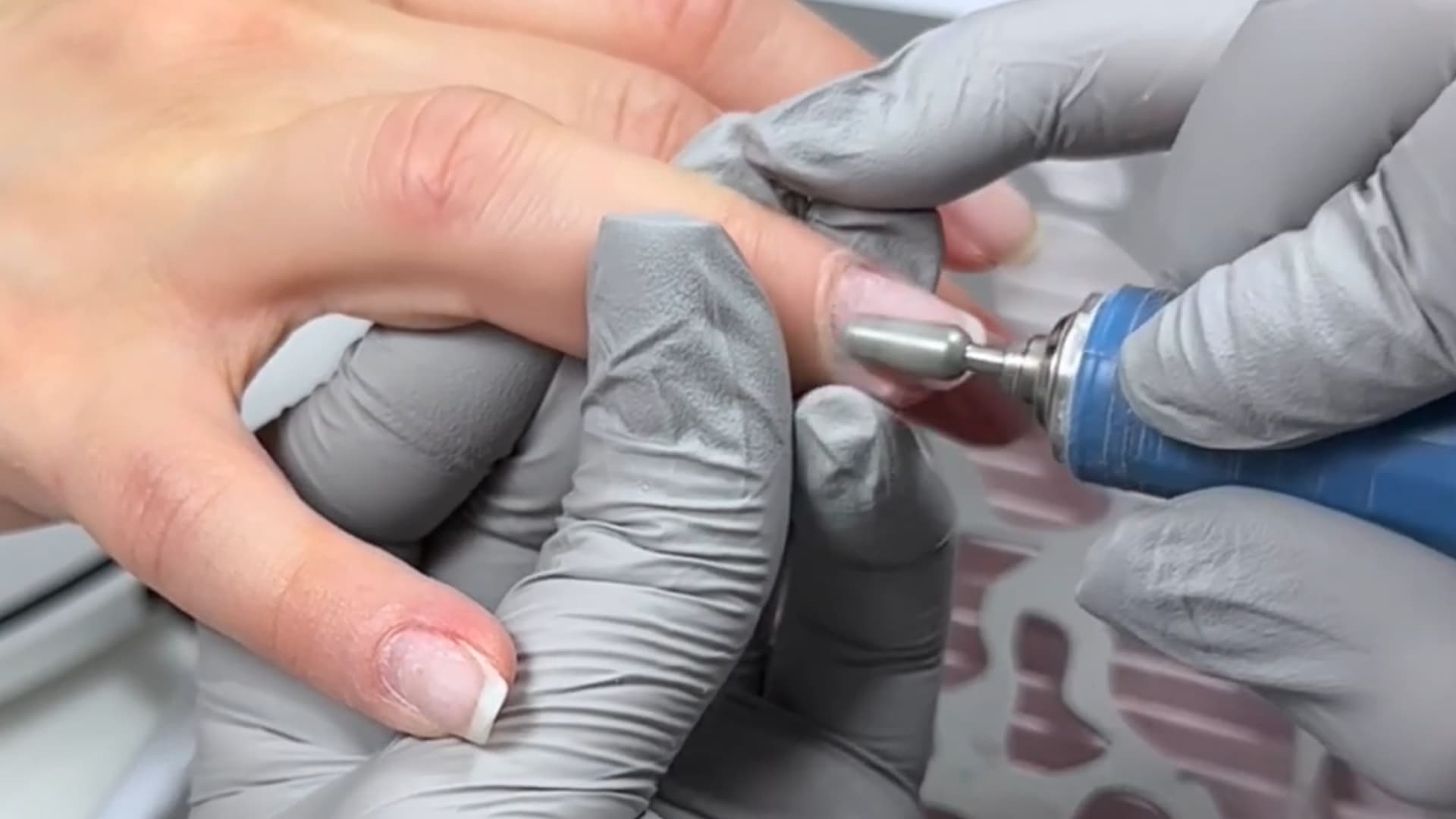 professional manicure showing electric drill smoothing the nail surface for gel application (1)
