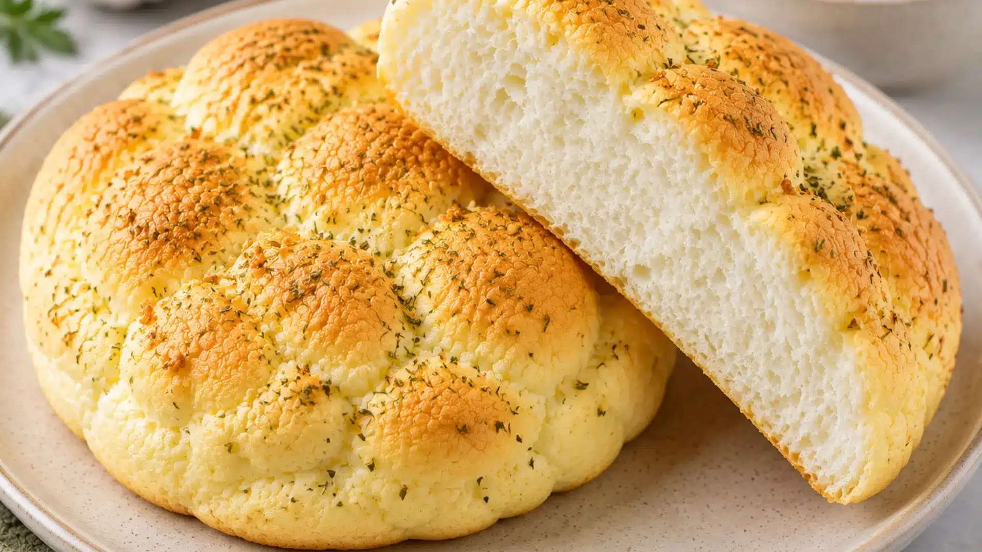 savory garlic herb cloud bread made from egg whites fluffy golden rolls sliced to show airy interior on ceramic plate natural light