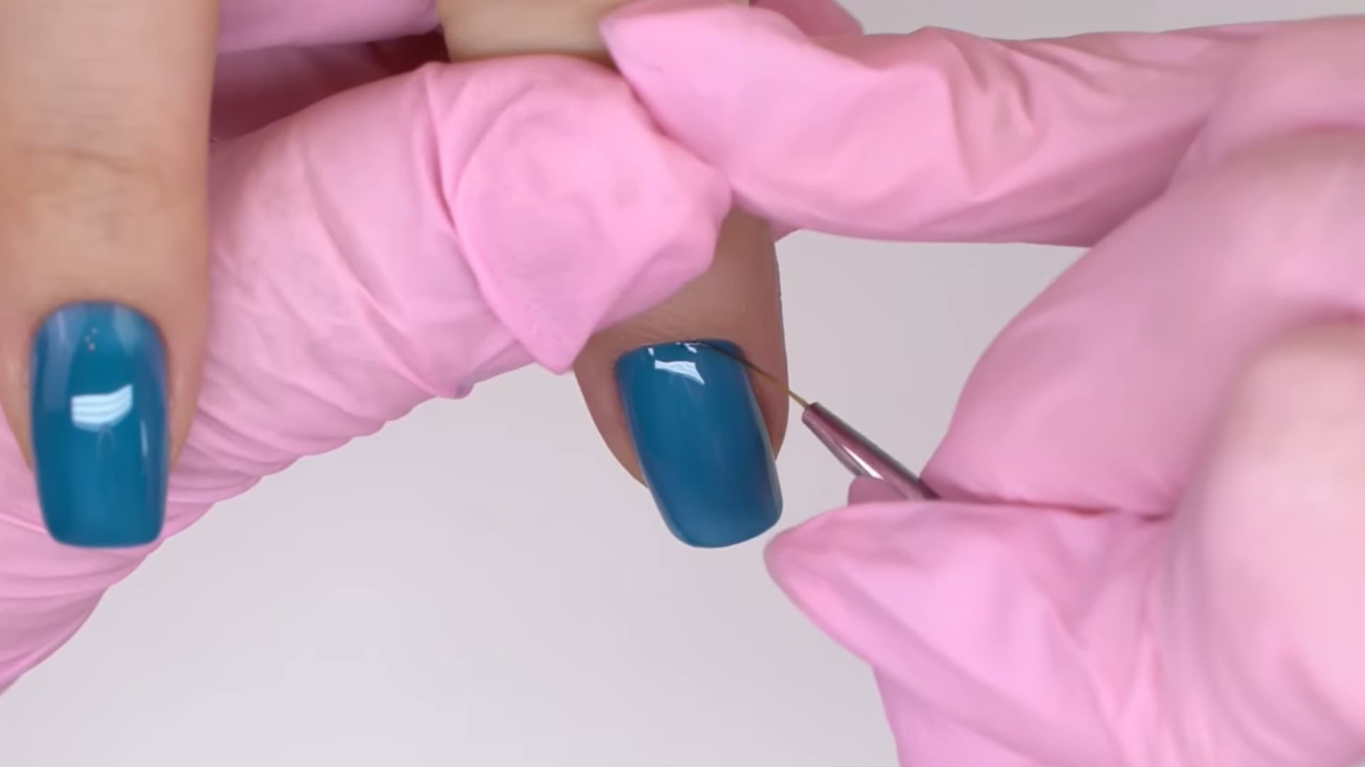 second layer of blue nail polish applied evenly over base coat for smooth glossy manicure finish