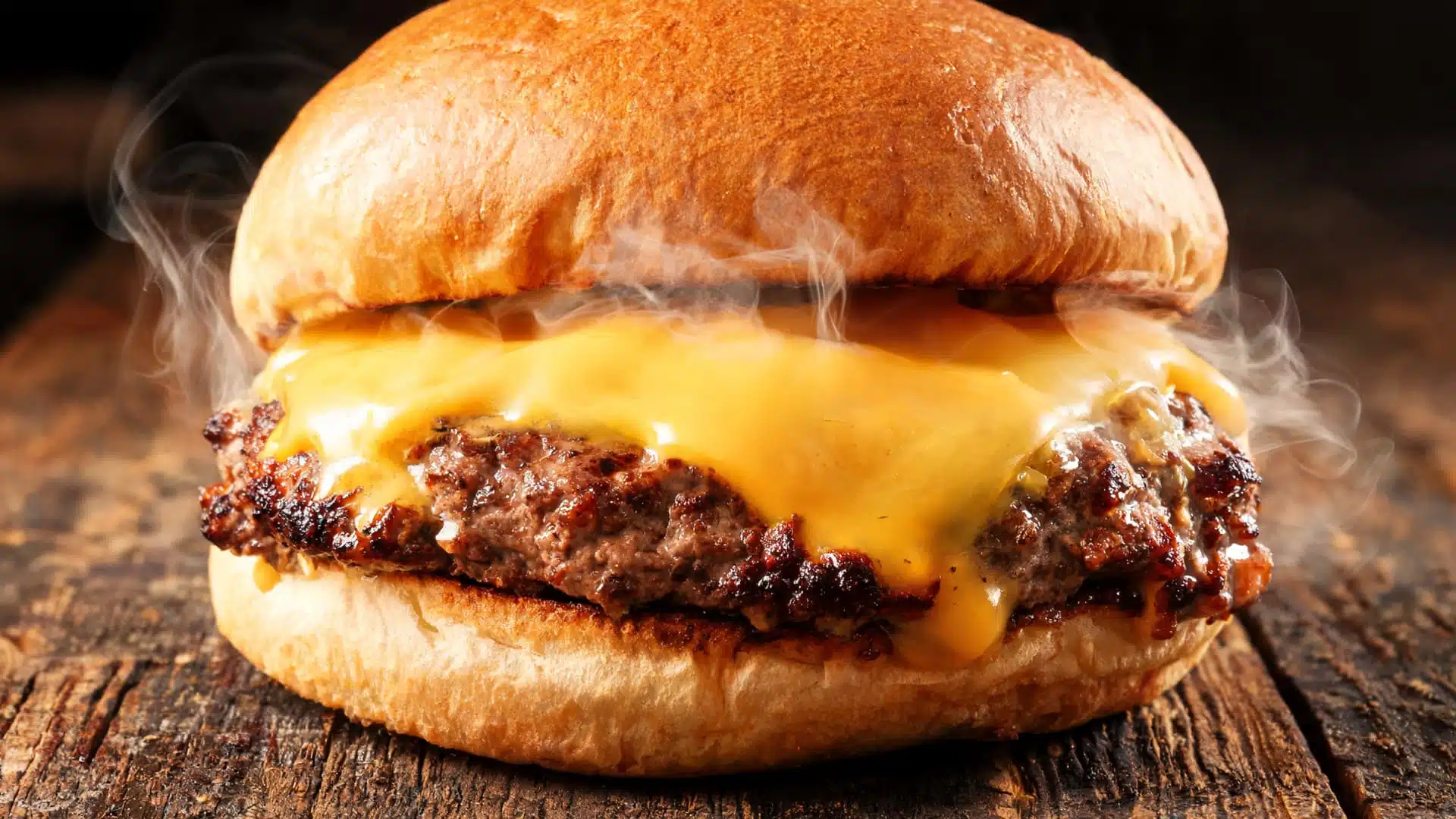 smash style burger with thin crispy beef patty caramelized edges melted cheese toasted bun steam rustic table