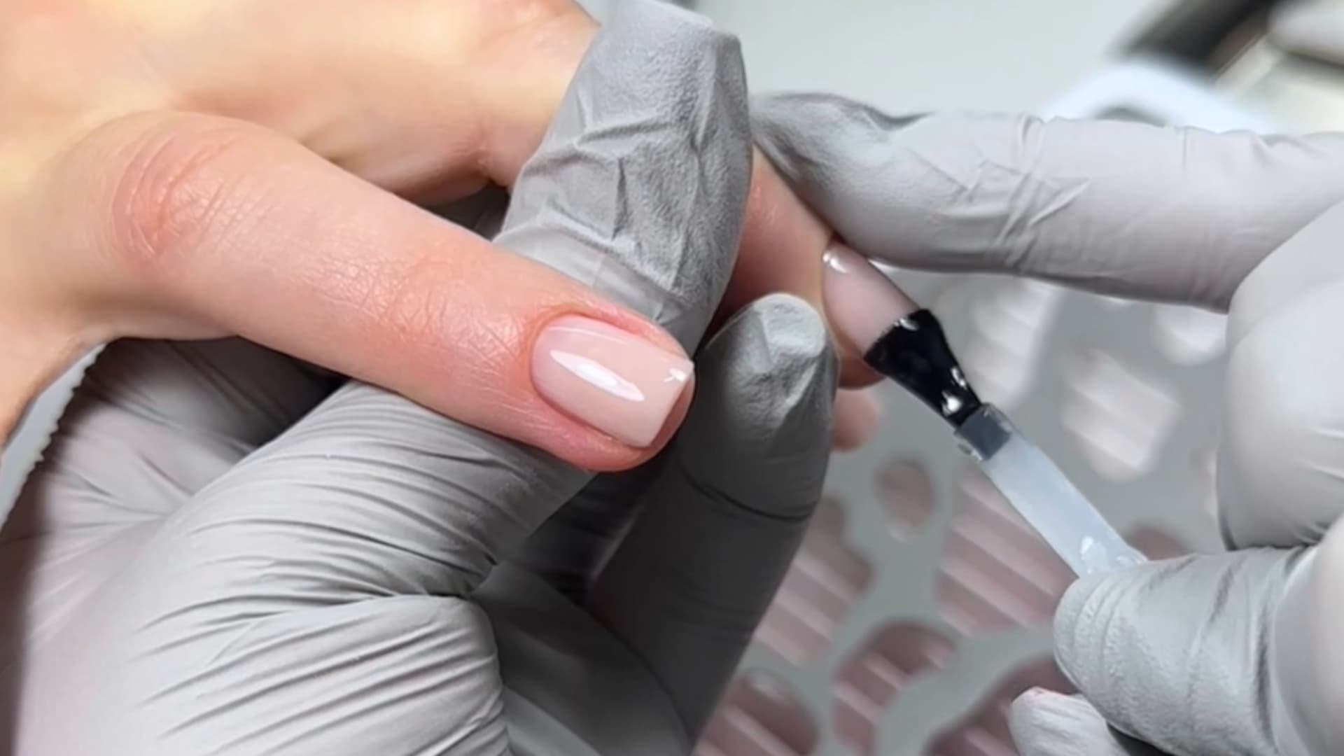 technician applying final gel polish coat with precision on natural nails