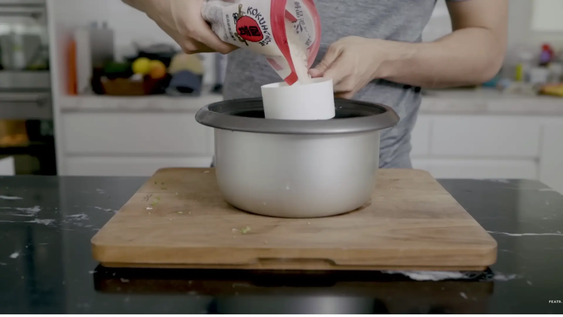 washing sushi rice under cold water in a bowl to remove starch before cooking for baked sushi