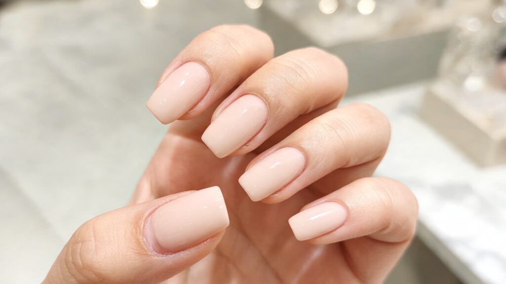 close-up of hands receiving a russian manicure in a bright modern nail salon, showing detailed cuticle work and precision filing