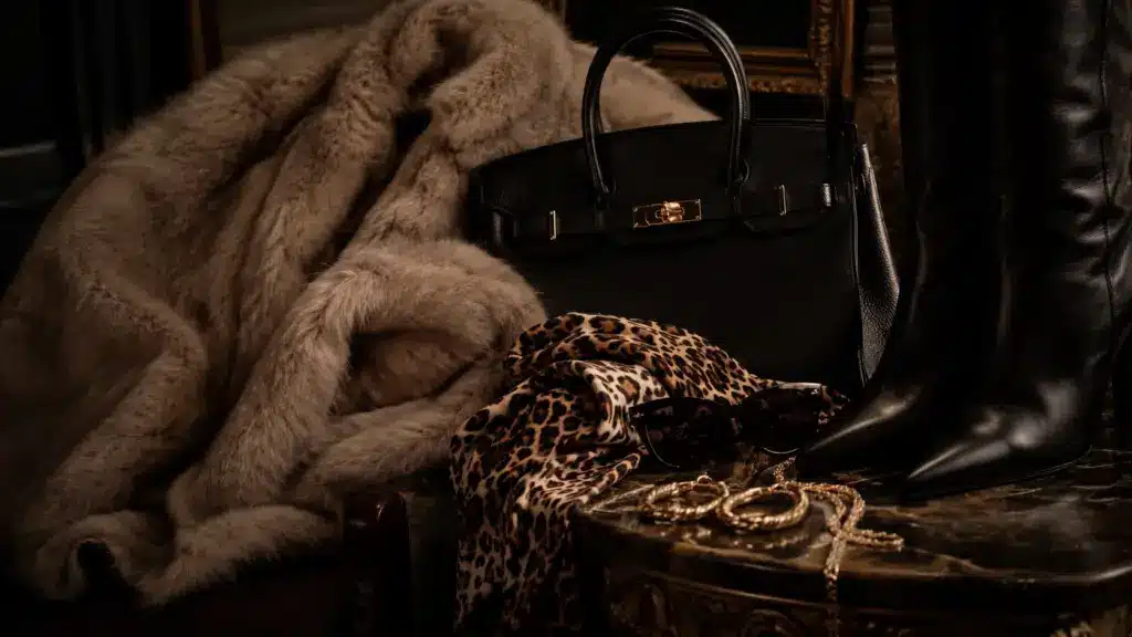 mob wife aesthetic cover image with faux fur, leopard print, gold jewelry, handbag, and black boots