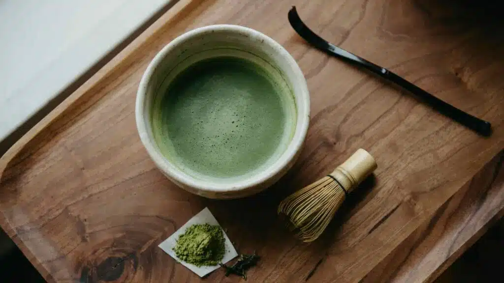 traditional matcha bowl with bamboo whisk and powder showing caffeine content