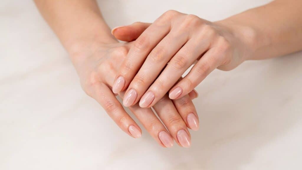 Freshly completed SNS dip powder manicure displayed on a marble salon table.