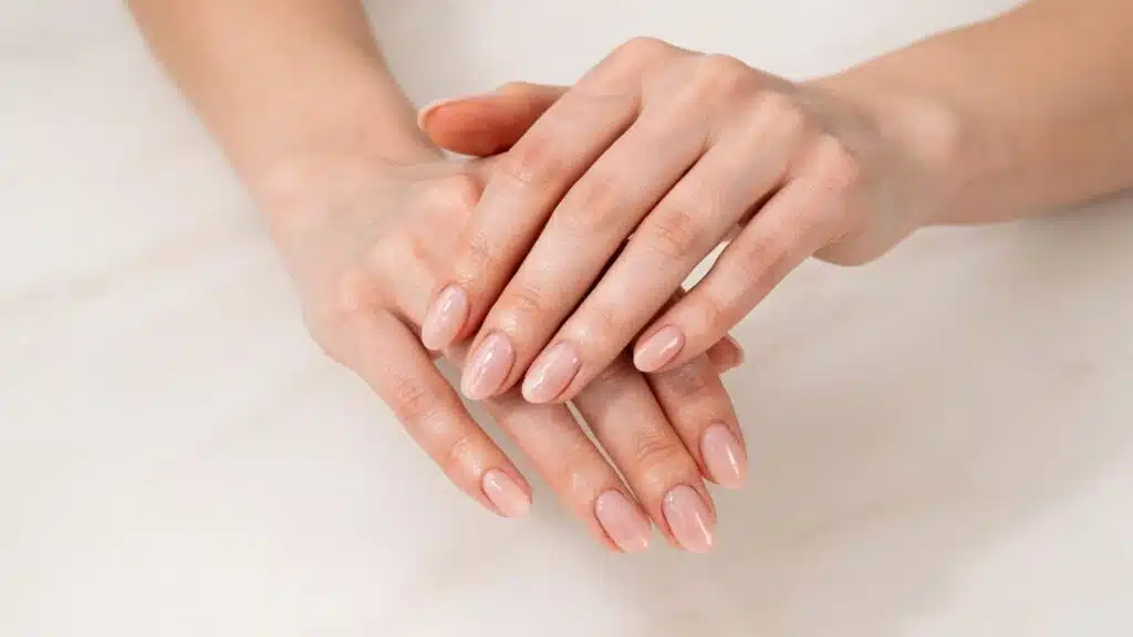 Freshly completed SNS dip powder manicure displayed on a marble salon table.