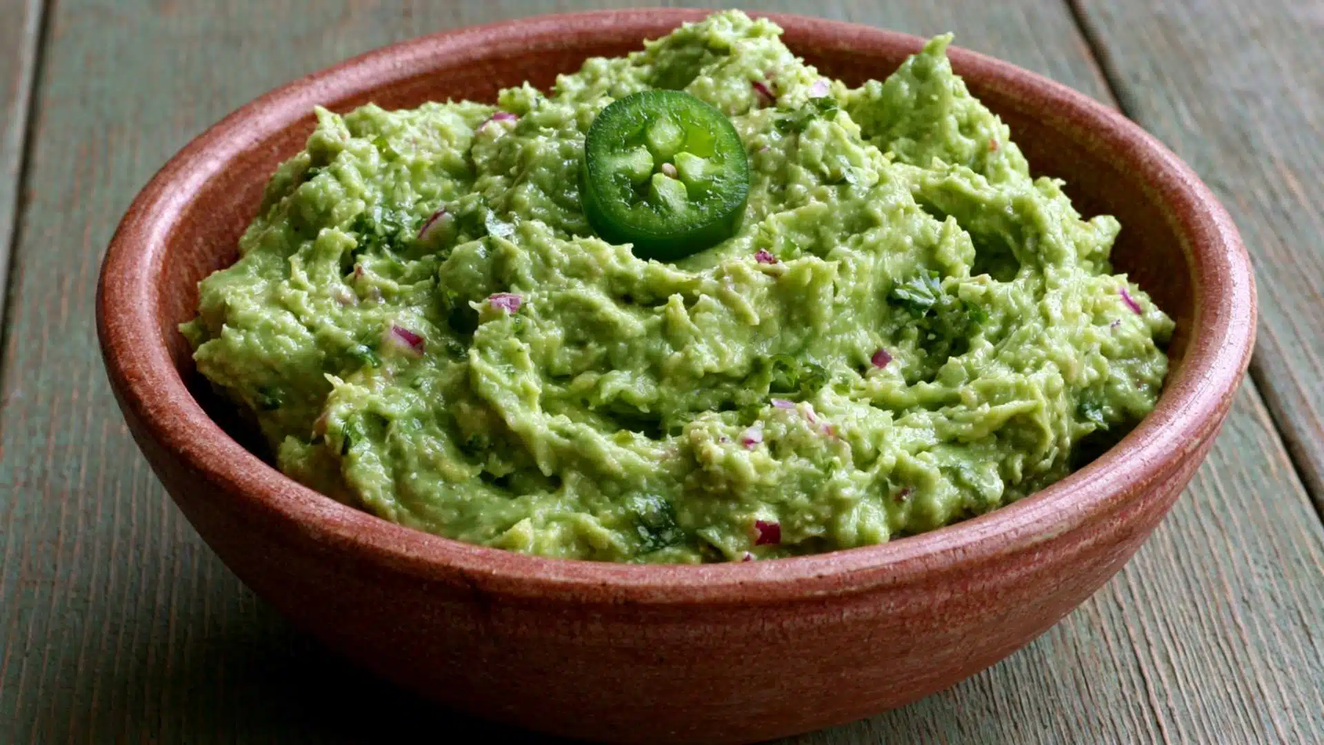 Spicy jalapeño and lime guacamole topped with a fresh jalapeño slice