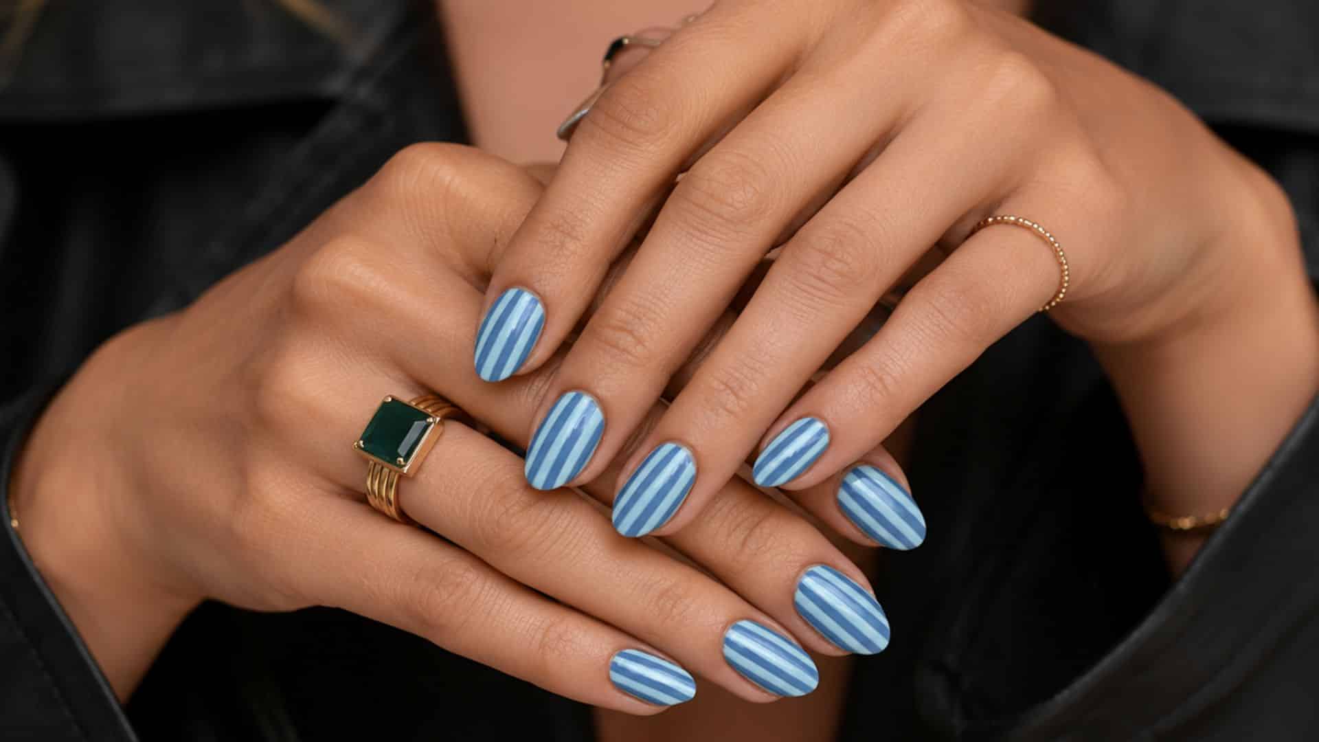 Close-up of hands with blue-striped pinstripe nail art