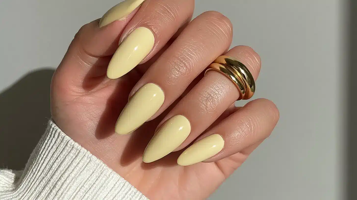 a hand with almond butter yellow nails perfect for summers