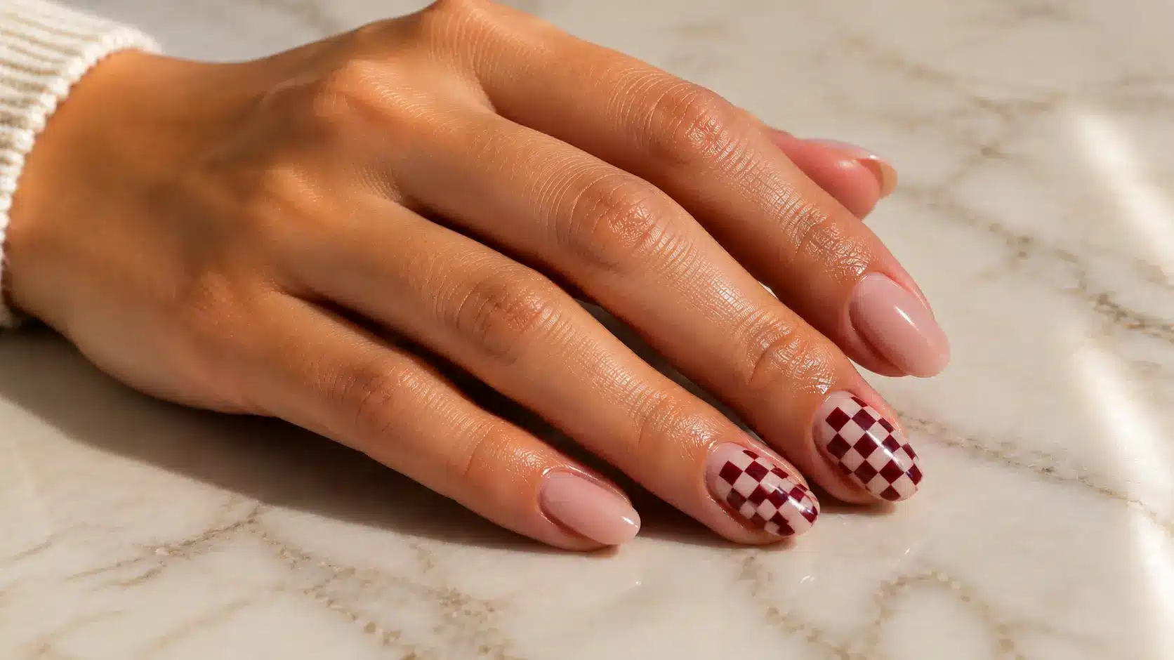 Checkerboard mini nail design featuring glossy nude nails with small grid accents for a simple nail art look