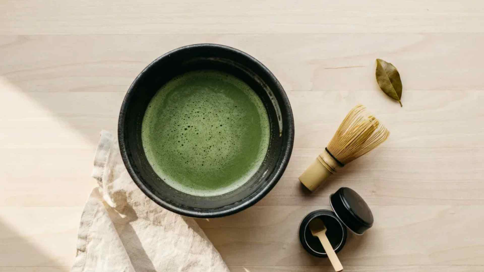Traditional matcha tea whisked in a ceramic bowl with bamboo whisk