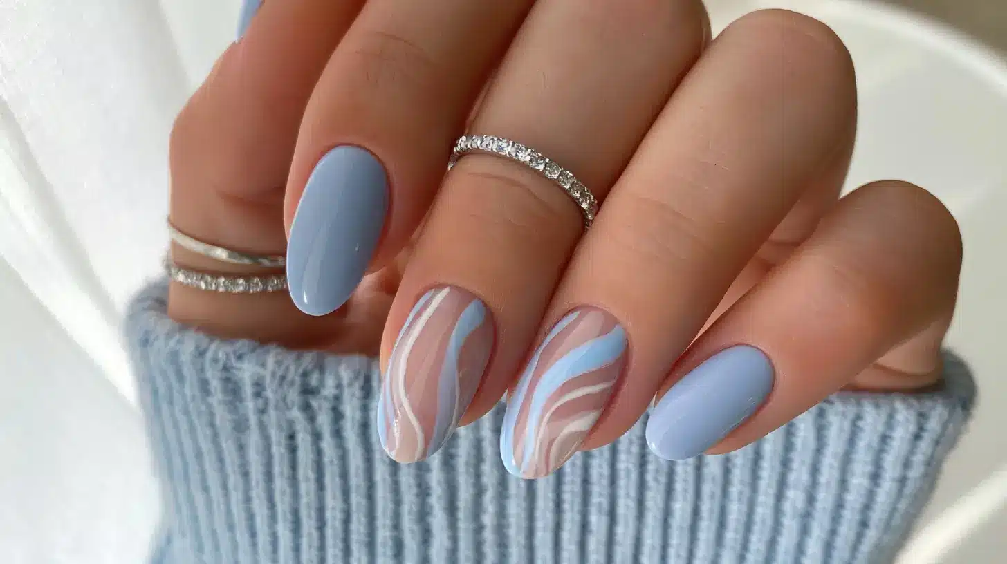 a closeup of cornflower blue nails with gold rings