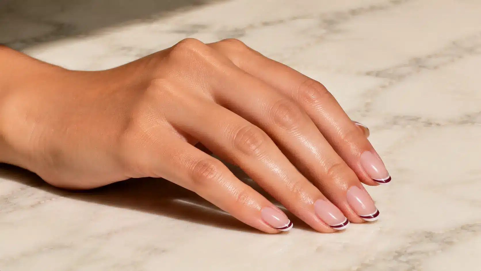 Double line French nail design featuring glossy nude nails with layered thin tips for a simple nail art look