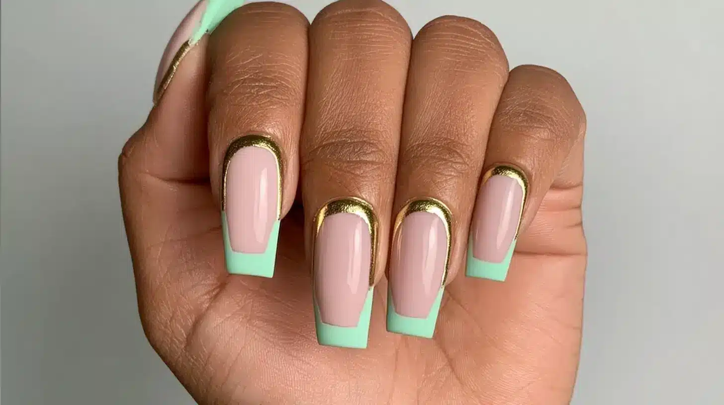 Long square nails with mint green tips and gold metallic French line accents.
