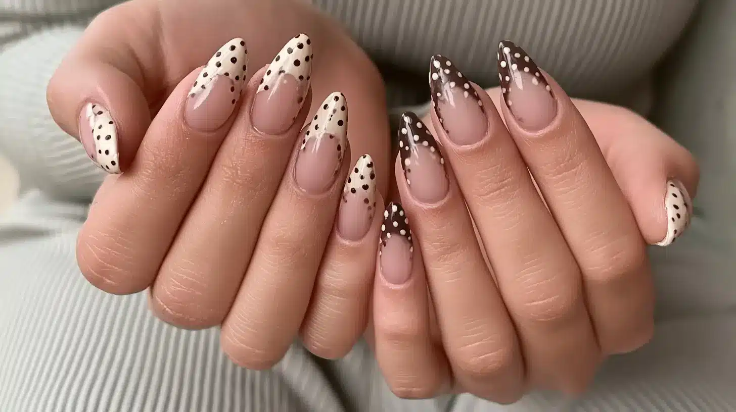 Almond nails with brown and cream polka dot French tips on both hands.