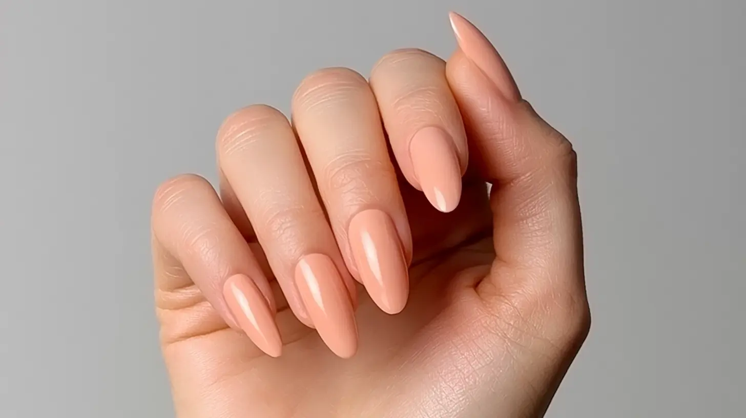 Glossy peach almond nails in a simple solid color manicure.