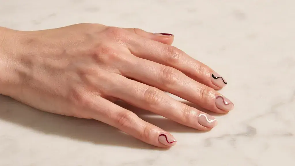 Single squiggle nail design featuring glossy nude nails with thin wavy lines for a simple nail art look